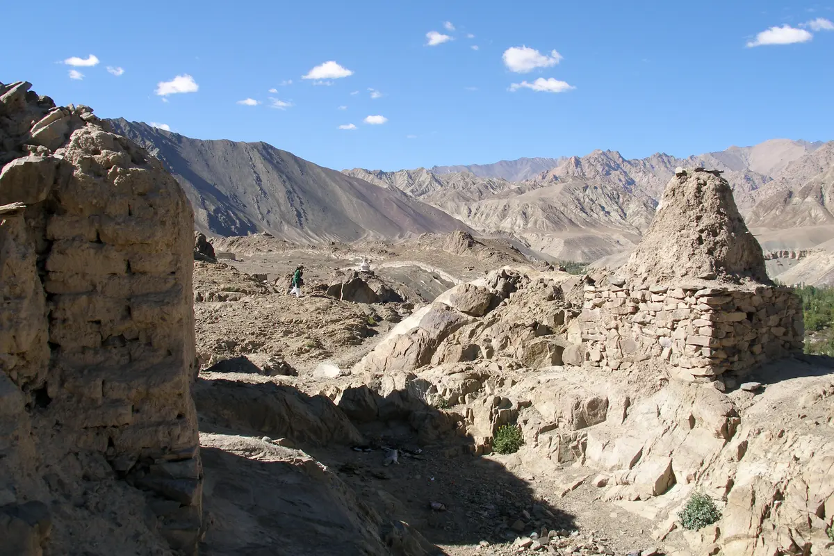 Old weathered chortens in Alchi with mountains behind