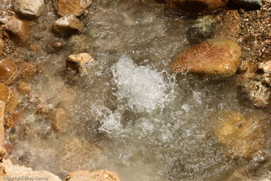 Hot water bubbling over stones at the Chumathang hot spring