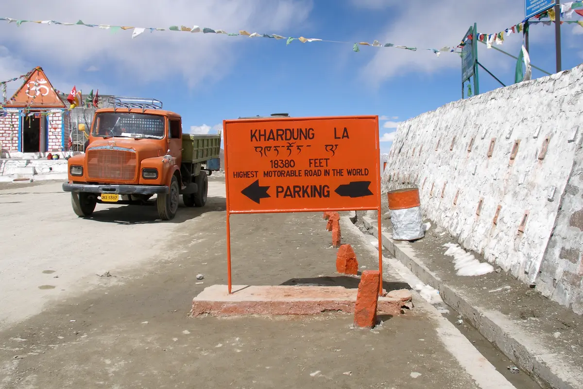 Khardung La signboard and a truck at the top of the pass