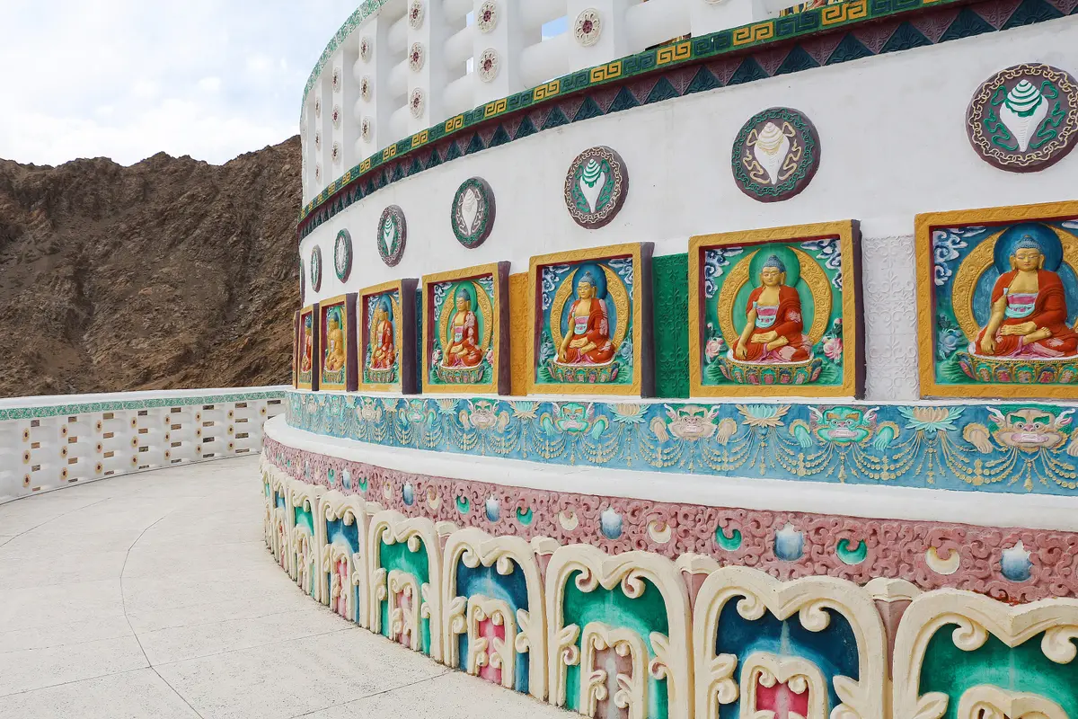Painted Buddha panels on the decorated base of Shanti Stupa