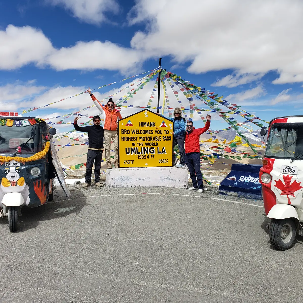 Auto rickshaws parked at the Umling La summit sign
