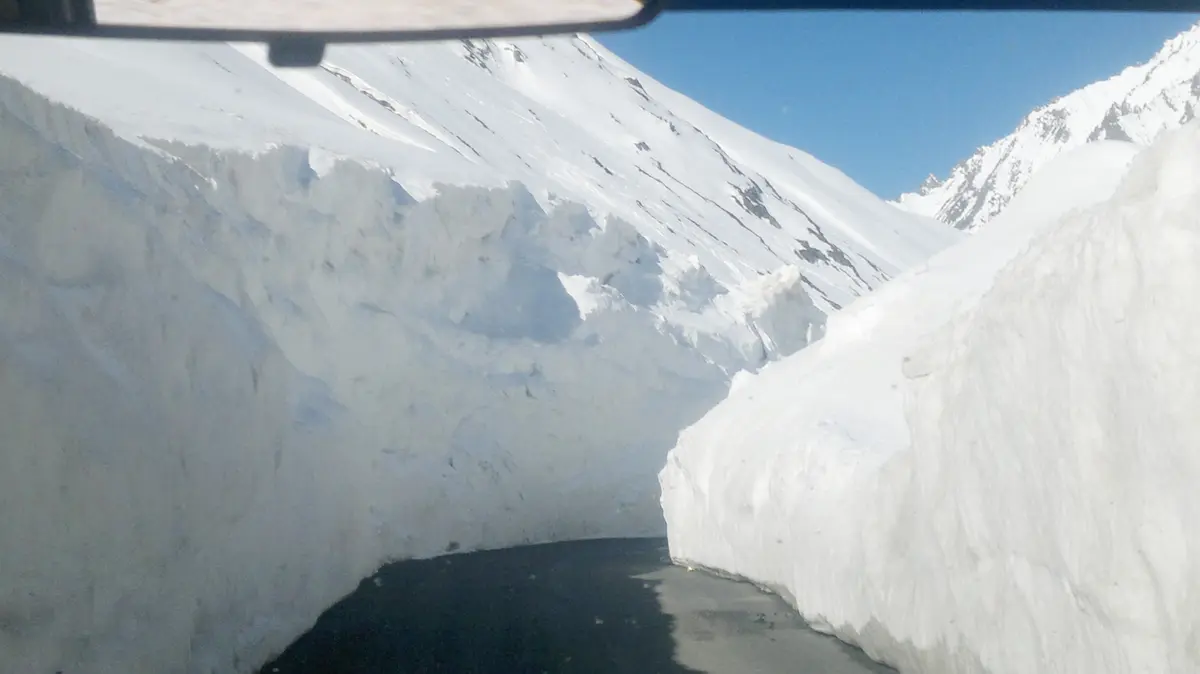 Road passing between tall walls of snow at Zojila